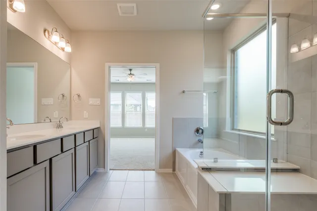 a bathroom with a tub sink and mirror