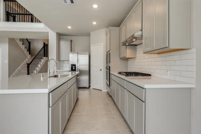 a kitchen with stainless steel appliances a sink stove and cabinets