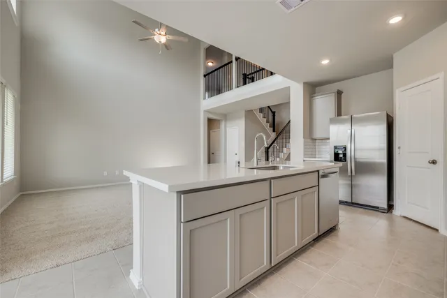 a kitchen with granite countertop a sink and refrigerator
