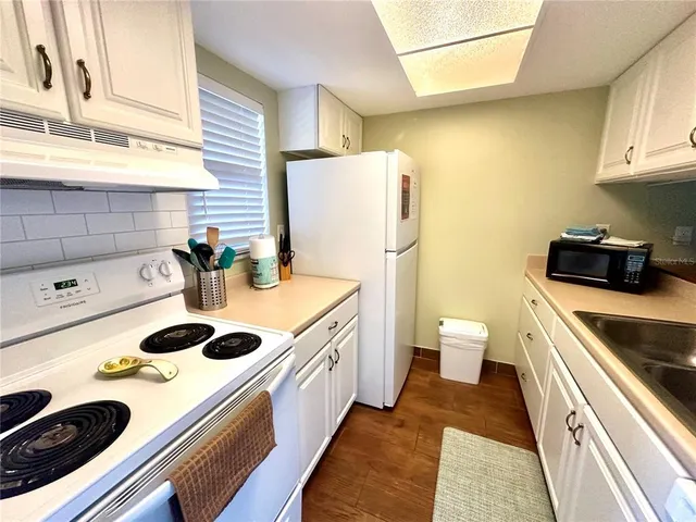a kitchen with a sink a stove and cabinets