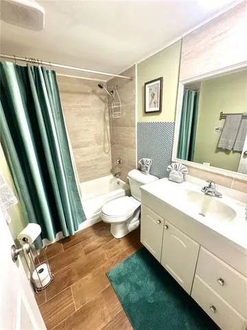 a bathroom with a sink a toilet a mirror and shower