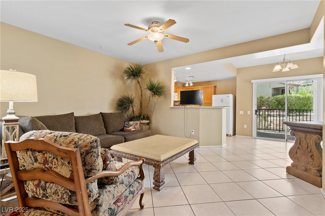 Living area with light tile patterned floors, and a ceiling fan