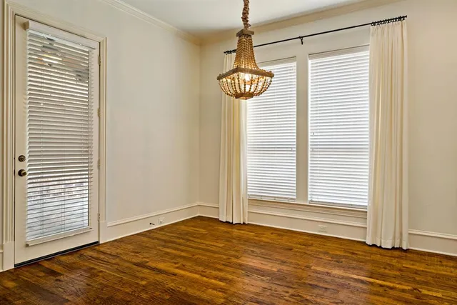 a view of a room with wooden floor and a window