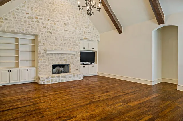 a view of a livingroom with wooden floor and a fireplace