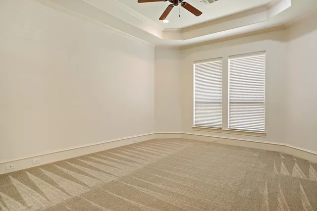 an empty room with a window and ceiling fan