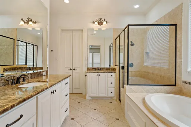 a spacious bathroom with a tub sink and mirror