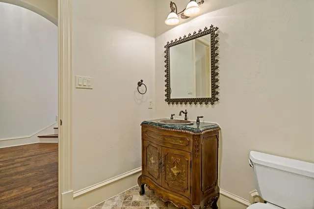 a bathroom with a toilet mirror vanity and sink