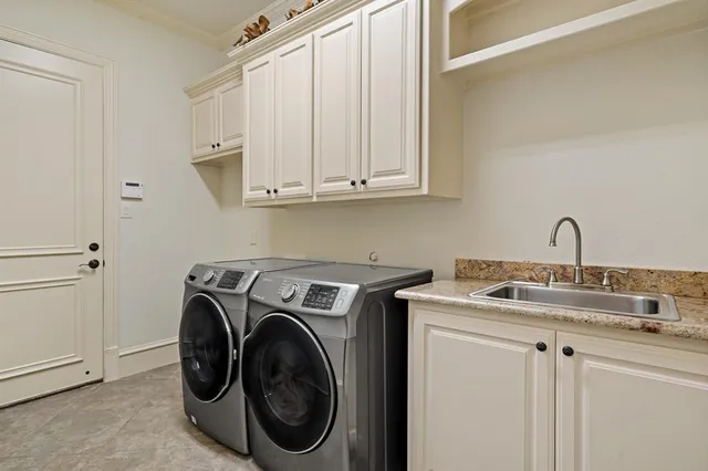 a utility room with sink dryer and washer