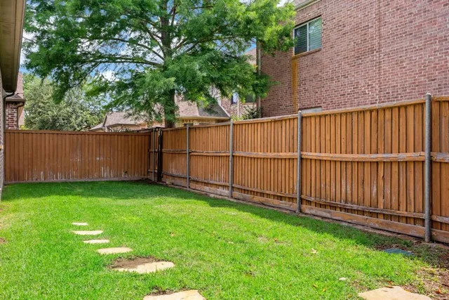 a view of a backyard with wooden fence