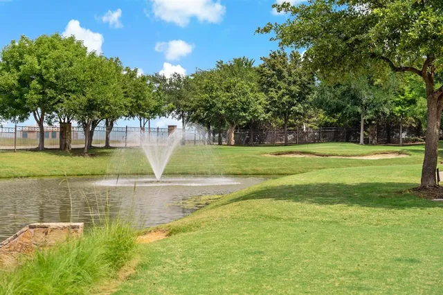 a view of a swimming pool with a yard and trees