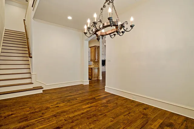 a view of a room with wooden floor and chandelier
