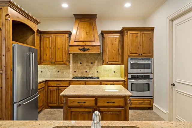 a kitchen with appliances a refrigerator and cabinets
