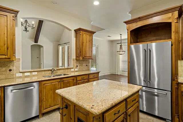 a kitchen with stainless steel appliances granite countertop a refrigerator a sink and a refrigerator