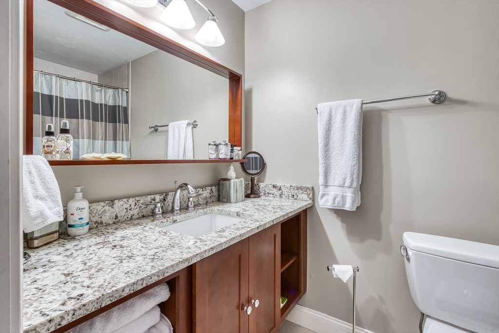 433 Main Street, Unit 4 Medfield, MA 02052 - Photo 21 of 36 a bathroom with a granite countertop sink and a mirror