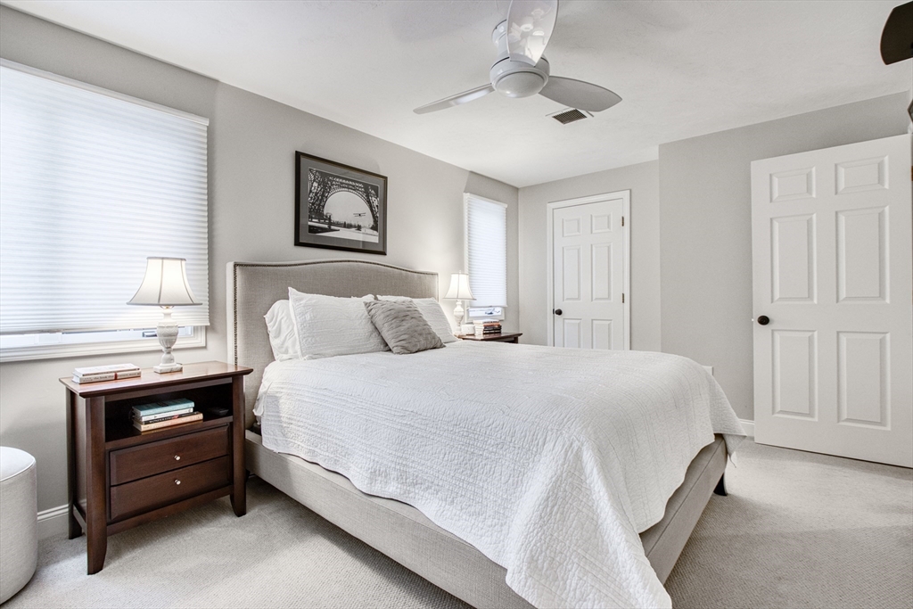 433 Main Street, Unit 4 Medfield, MA 02052 - Photo 23 of 36 a spacious bedroom with a bed and a chandelier