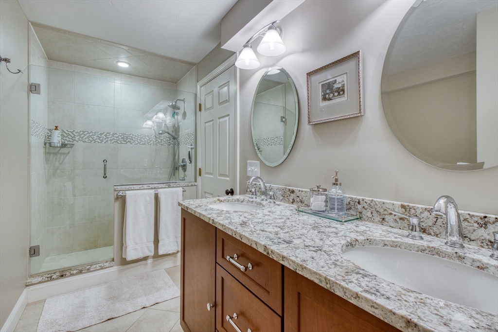 433 Main Street, Unit 4 Medfield, MA 02052 - Photo 25 of 36 a bathroom with a granite countertop sink mirror and shower