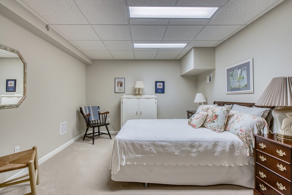 433 Main Street, Unit 4 Medfield, MA 02052 - Photo 29 of 36 a bedroom with a bed a table and chair