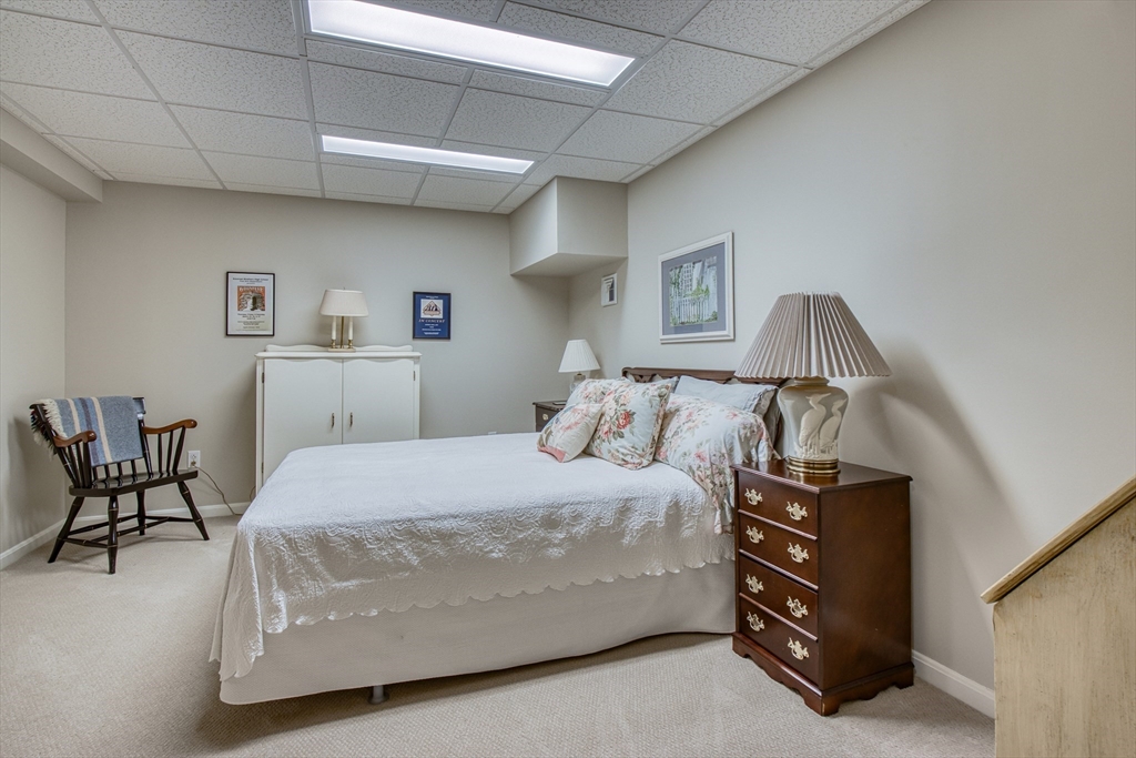 433 Main Street, Unit 4 Medfield, MA 02052 - Photo 30 of 36 a bedroom with a bed and chair