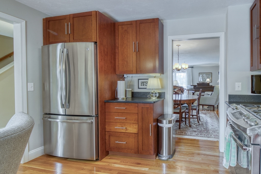 433 Main Street, Unit 4 Medfield, MA 02052 - Photo 9 of 36 a kitchen with stainless steel appliances a refrigerator and wooden cabinets