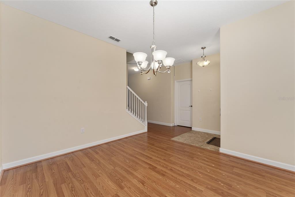 1355 Vasey Road Apopka, FL 32703 - Photo 13 of 41 a view of a chandelier in hallway with wooden floor