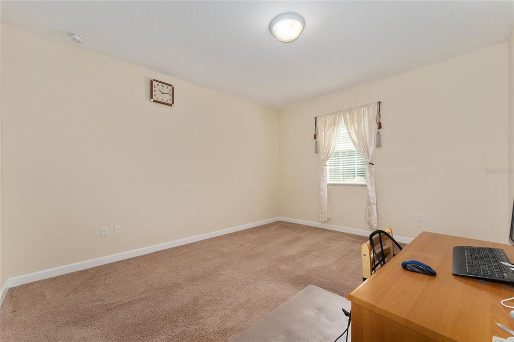 1355 Vasey Road Apopka, FL 32703 - Photo 14 of 41 a room that has a bed and a desk in it