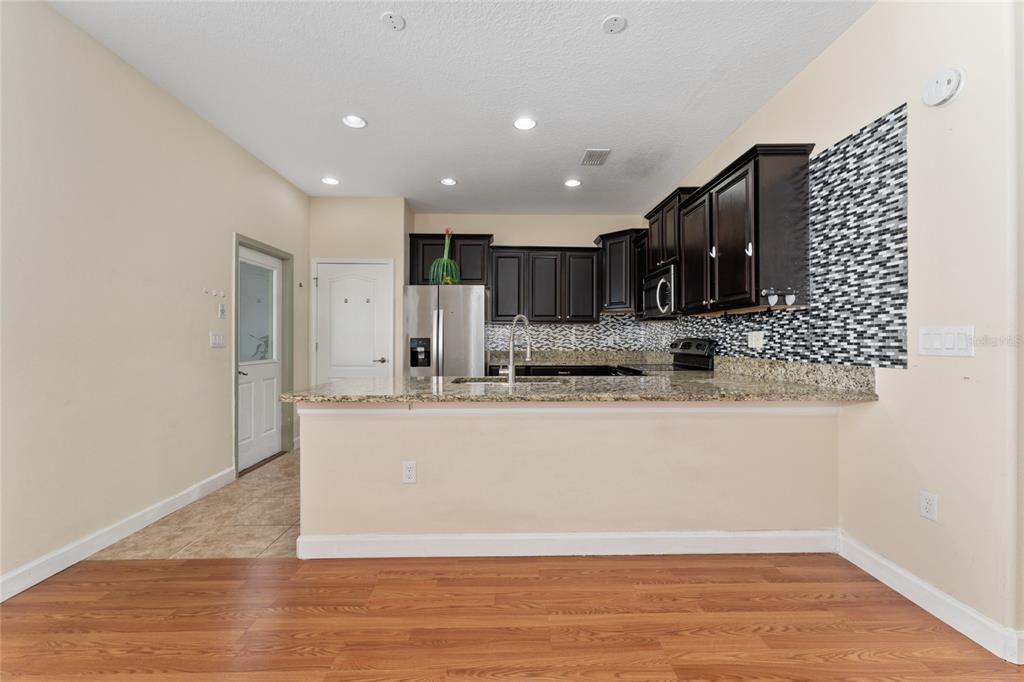 1355 Vasey Road Apopka, FL 32703 - Photo 19 of 41 a large kitchen with stainless steel appliances granite countertop a stove a sink and a refrigerator