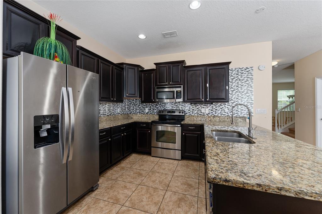1355 Vasey Road Apopka, FL 32703 - Photo 20 of 41 a kitchen with stainless steel appliances granite countertop a refrigerator stove and oven
