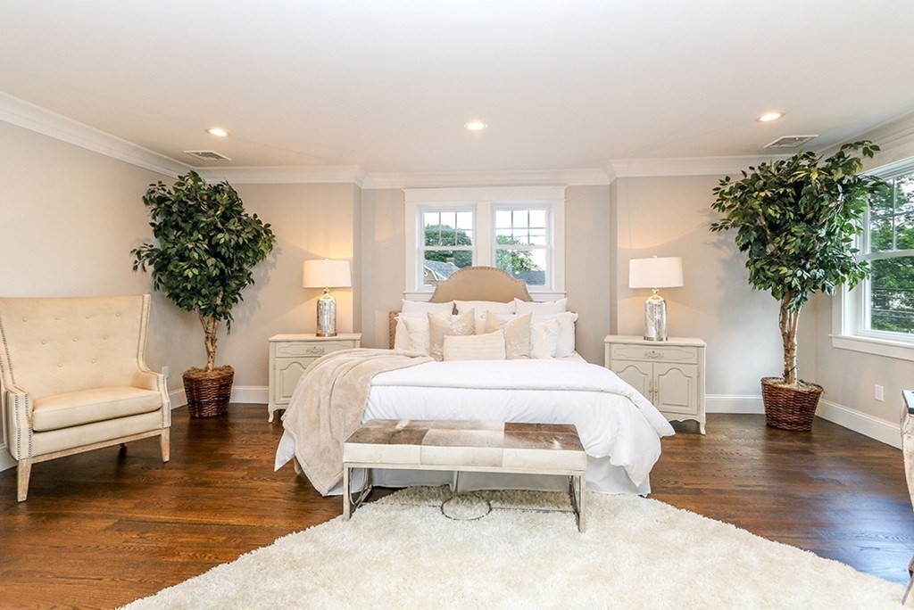 80 Sachem Road Needham, MA 02494 - Photo 17 of 26 a spacious bedroom with a bed a couch and a potted plant