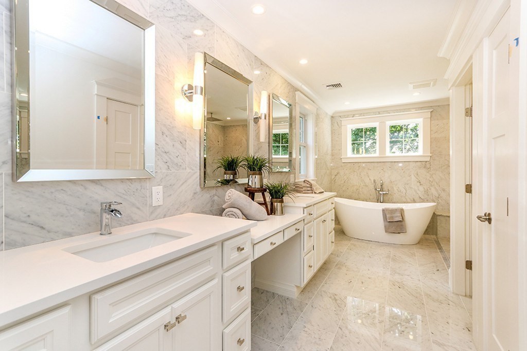 80 Sachem Road Needham, MA 02494 - Photo 19 of 26 a bathroom with a double vanity sink large mirror and a bathtub