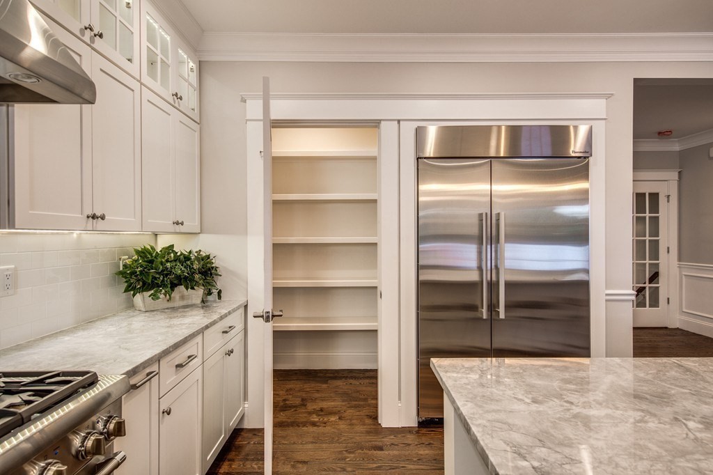 80 Sachem Road Needham, MA 02494 - Photo 8 of 26 a kitchen with a refrigerator and a white wooden cabinets