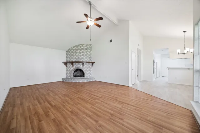 a view of empty room with a fireplace and wooden floor