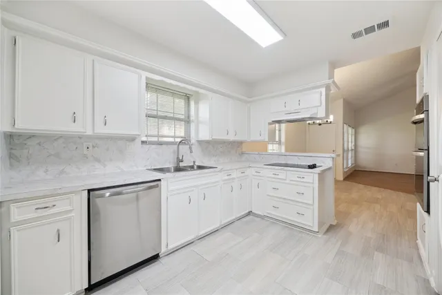 a kitchen with granite countertop white cabinets and white appliances