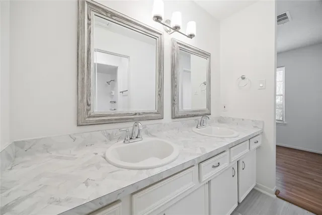 a bathroom with double sink and a mirror