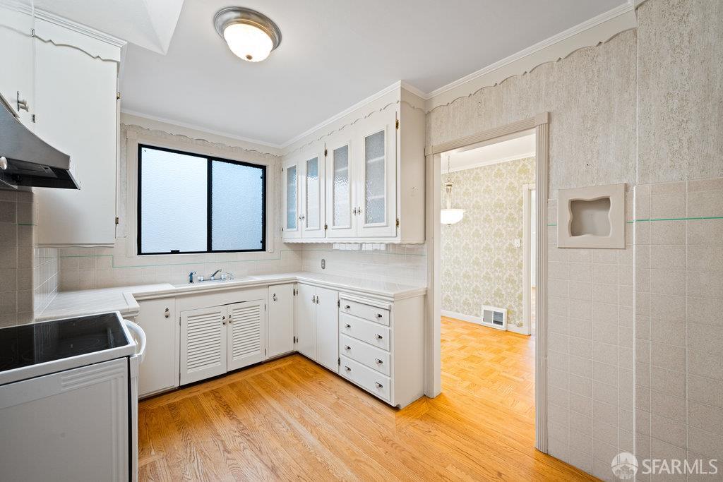 1653 16th Avenue San Francisco, CA 94122 - Photo 15 of 33 a view of a kitchen with sink and dishwasher with wooden floor