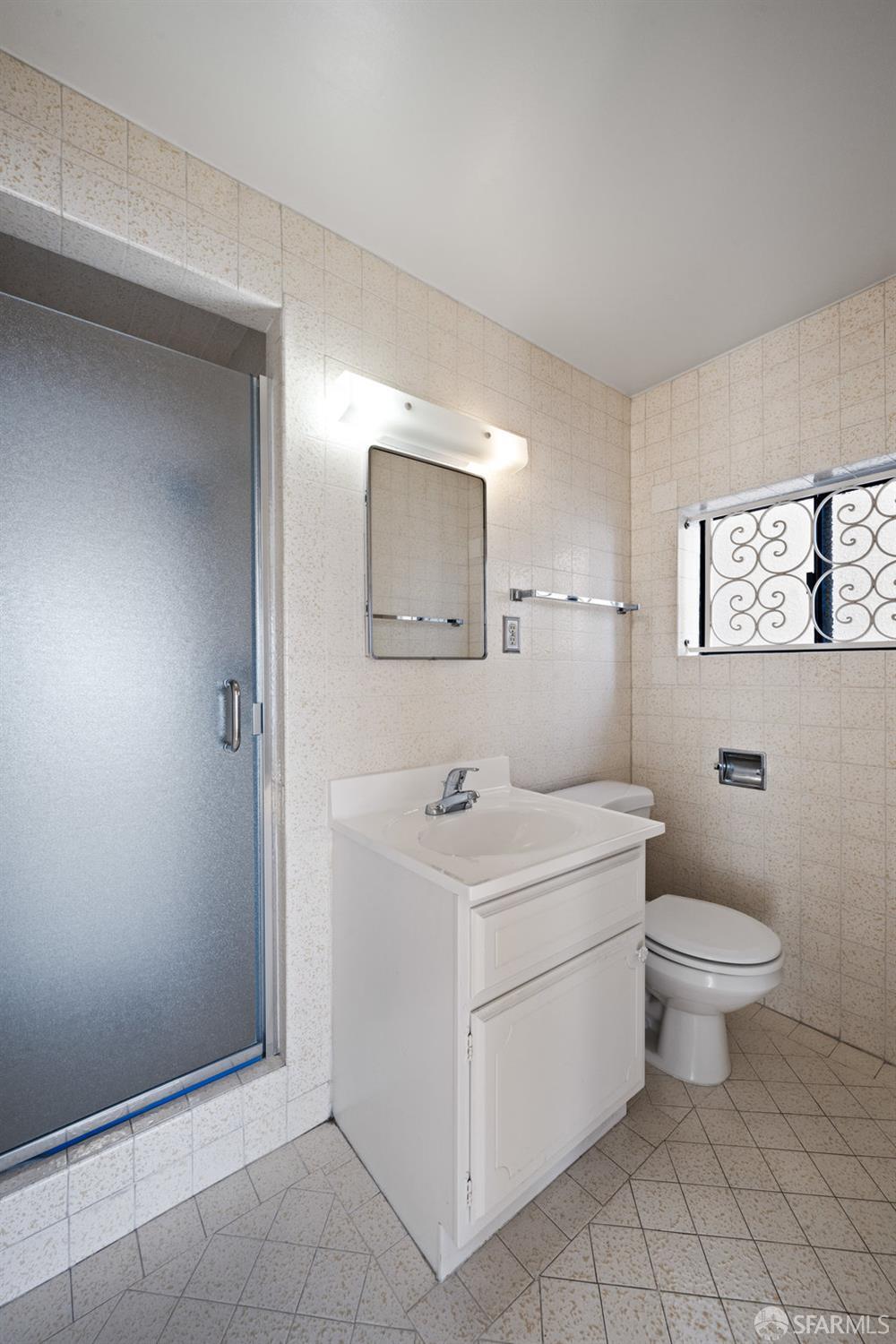 1653 16th Avenue San Francisco, CA 94122 - Photo 29 of 33 a bathroom with a toilet sink and mirror