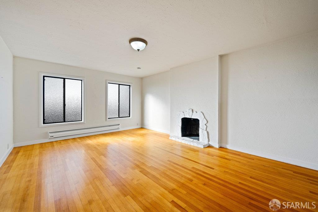 1653 16th Avenue San Francisco, CA 94122 - Photo 30 of 33 a view of empty room with wooden floor and fireplace