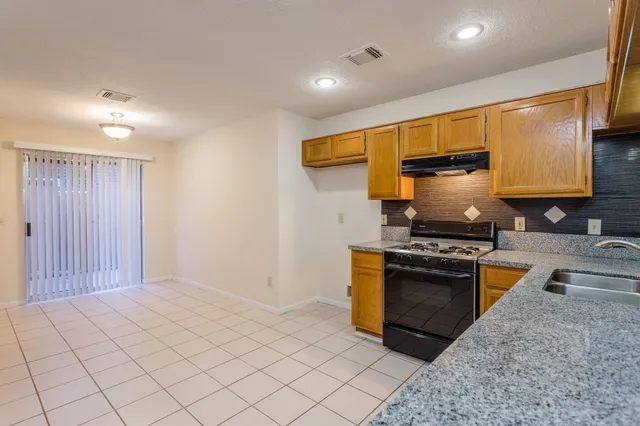 a kitchen with stainless steel appliances granite countertop a stove a sink and a refrigerator