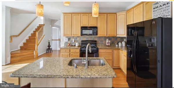 a kitchen with stainless steel appliances granite countertop a refrigerator a stove and a sink