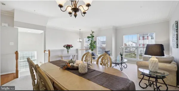a dining room with furniture potted plants and wooden floor