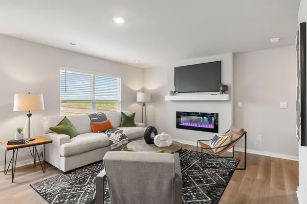 a living room with furniture a flat screen tv and a fireplace