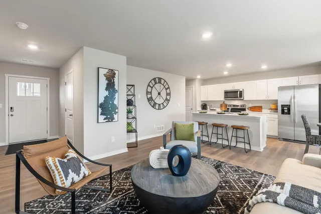 a living room with furniture and a dining table with kitchen view