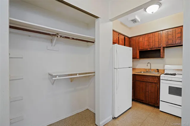 a white refrigerator freezer and a stove sitting inside of a kitchen