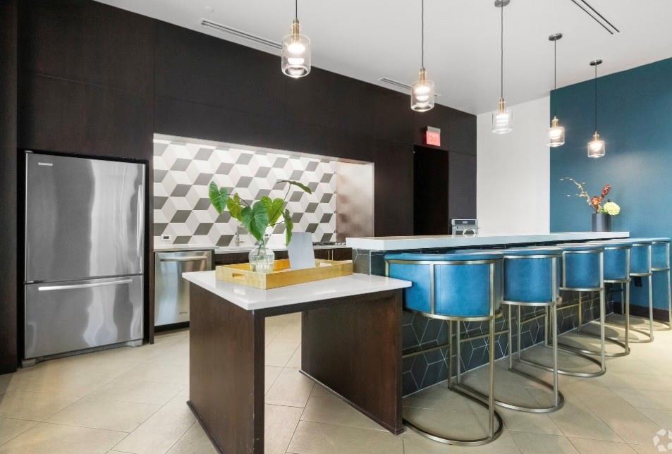 1700 Cedar Springs Road, Unit 2508 Dallas, TX 75201 - Photo 23 of 40 a kitchen with stainless steel appliances kitchen island granite countertop a table chairs and a refrigerator