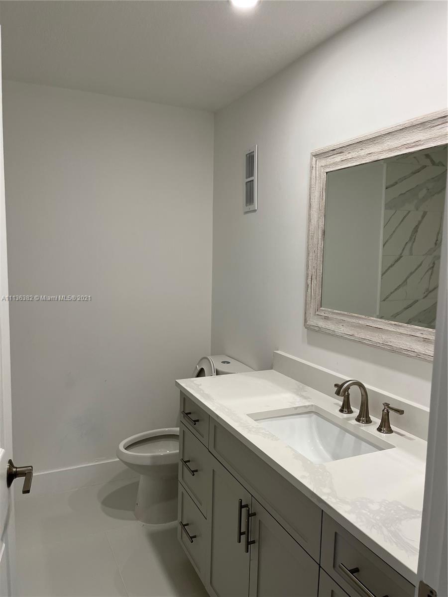 8309 Springtree Road, Unit 8309 Boca Raton, FL 33496 - Photo 14 of 18 a bathroom with a granite countertop toilet sink and mirror