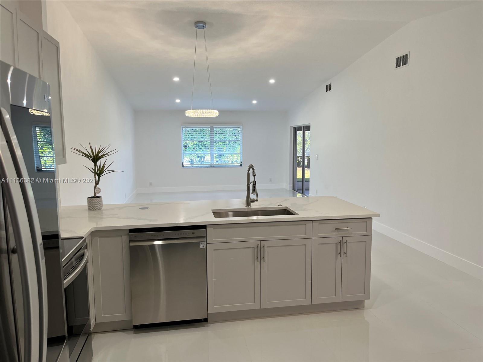 8309 Springtree Road, Unit 8309 Boca Raton, FL 33496 - Photo 4 of 18 a kitchen with a sink and cabinets