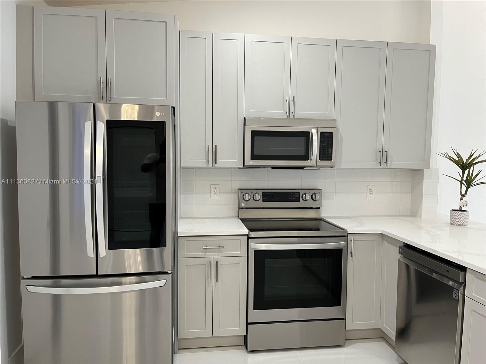 8309 Springtree Road, Unit 8309 Boca Raton, FL 33496 - Photo 6 of 18 a kitchen with cabinets stainless steel appliances and a counter space