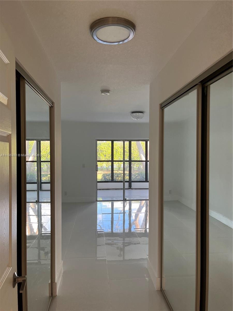 8309 Springtree Road, Unit 8309 Boca Raton, FL 33496 - Photo 9 of 18 a view of empty room with wooden floor and fan