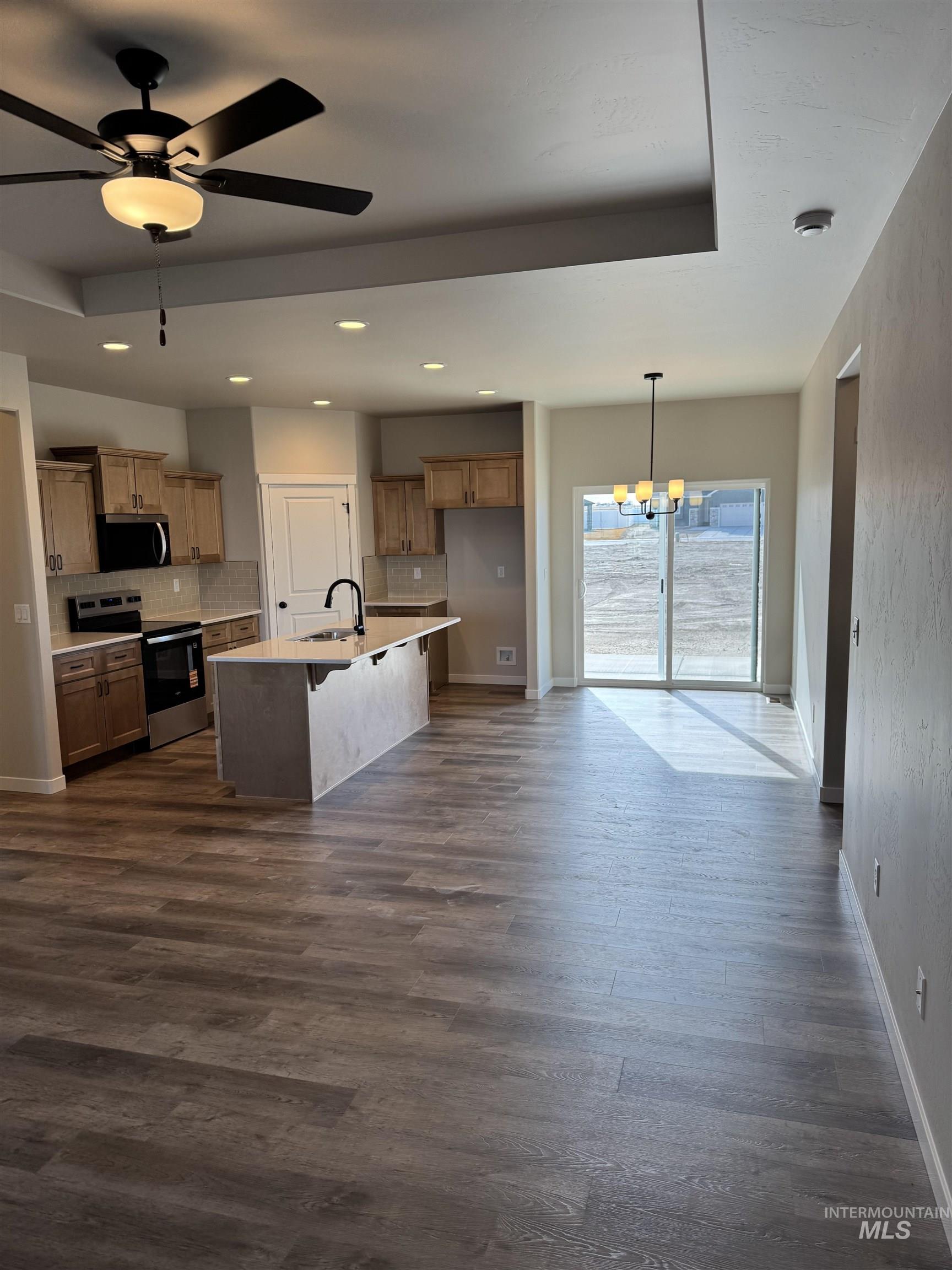 2064 Harrison Street South Twin Falls, ID 83301 - Photo 4 of 29 Kitchen featuring suspended lighting, stainless steel appliances, a ceiling fan, a breakfast bar area, and backsplash