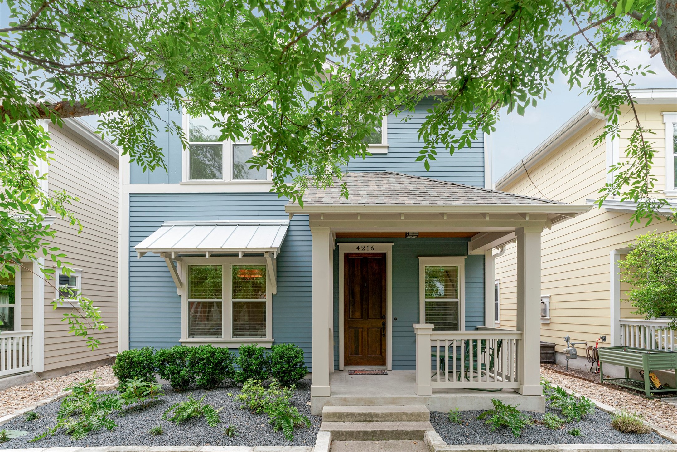 a front view of a house with a tree