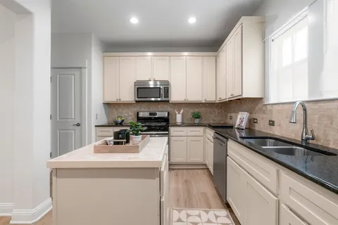 a kitchen with sink a microwave and cabinets